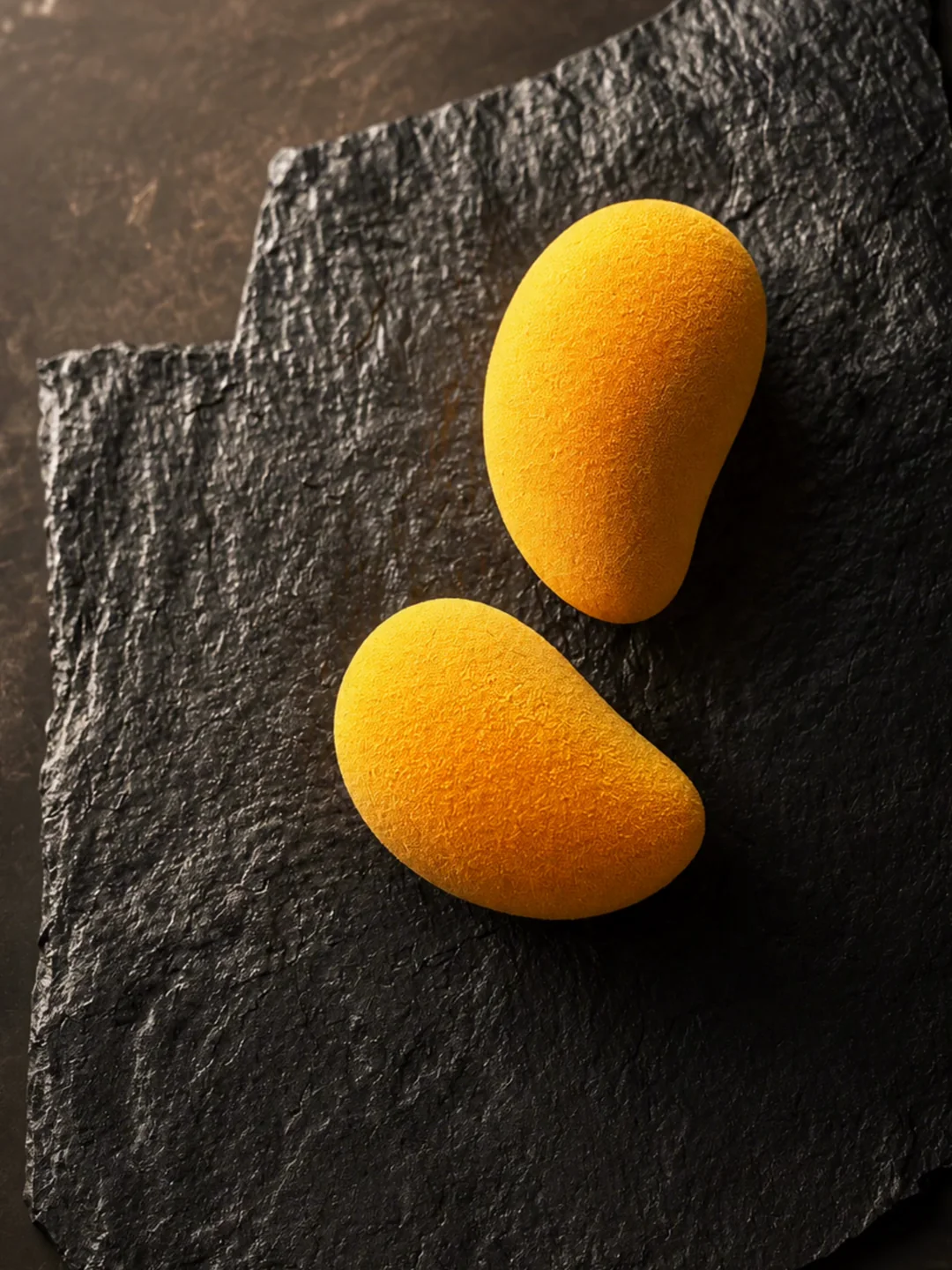 Mango-shaped entremets on a dark slate