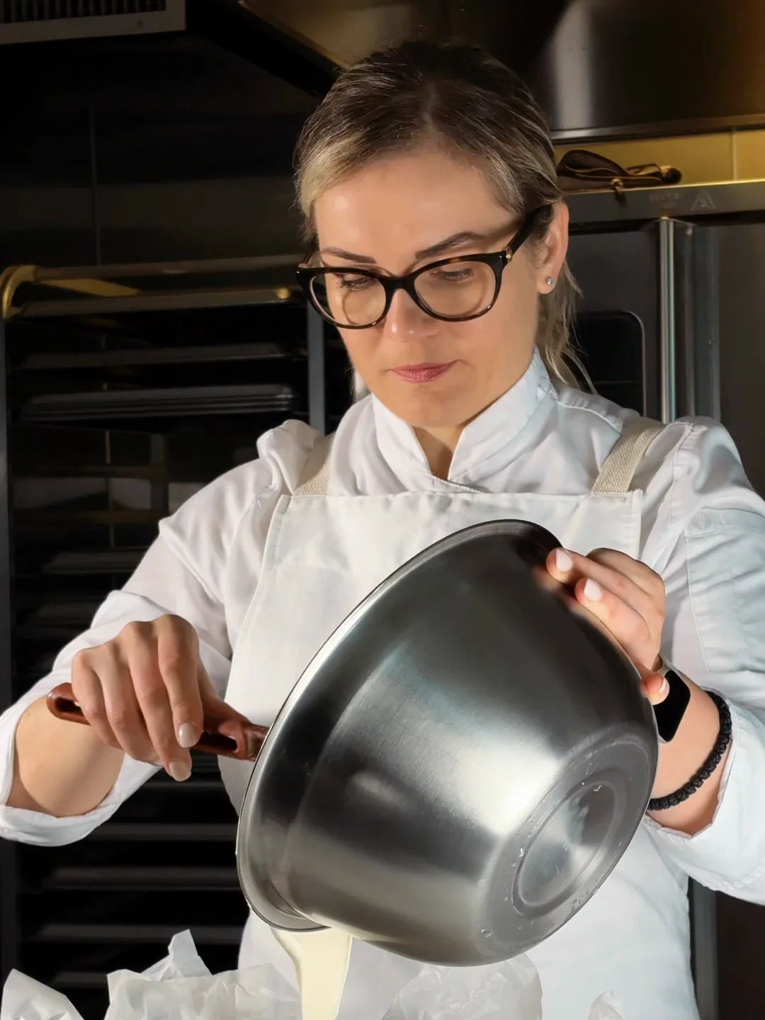 Executive pastry chef pouring cheesecake batter in a professional hotel pastry kitchen