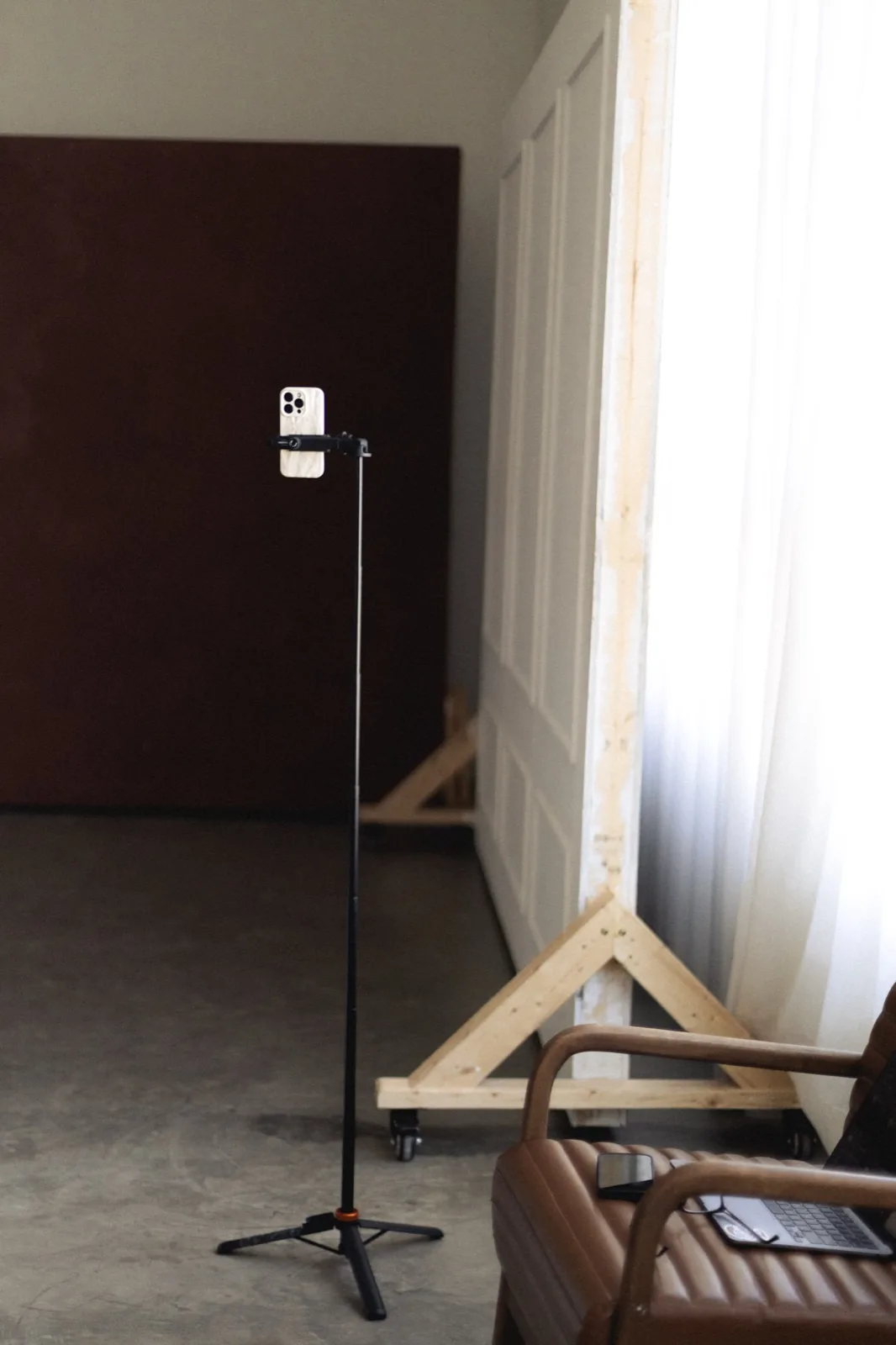A phone mounted on a tripod, set up for filming client marketing content.